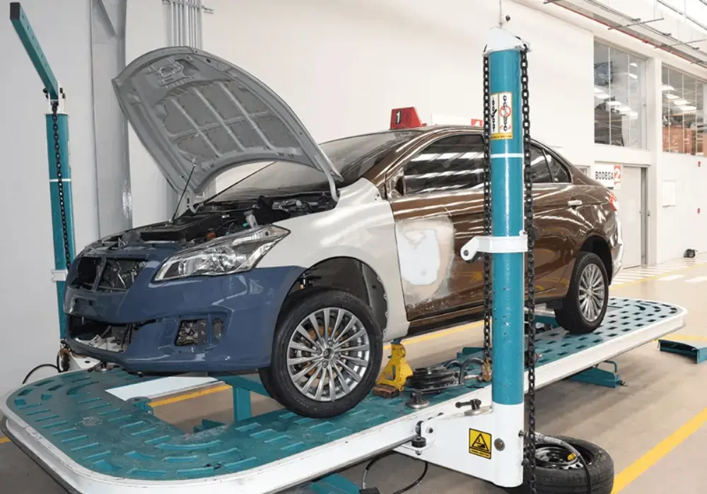 Auto sedán Suzuki elevado en una plataforma de reparación automotriz